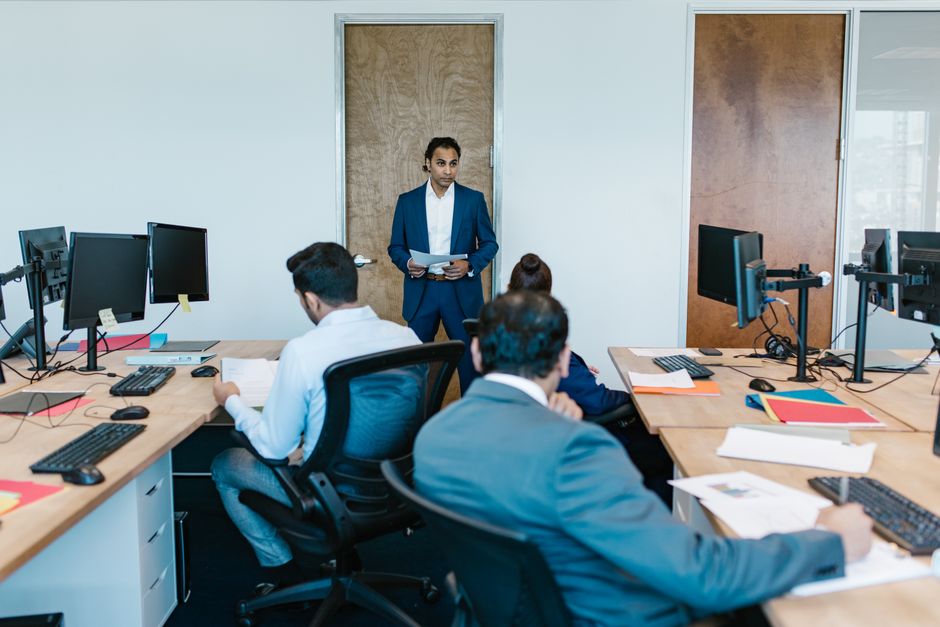 Business meeting with diverse team in modern office space, discussing projects.